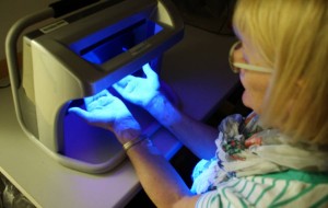 Die UV-Lampe bringt es an Licht: Gisela Bednarek hat das Desinfektionsmittel perfekt auf ihre Hände aufgetragen.  Foto: Elke Blüml/Missionsärztliches Institut